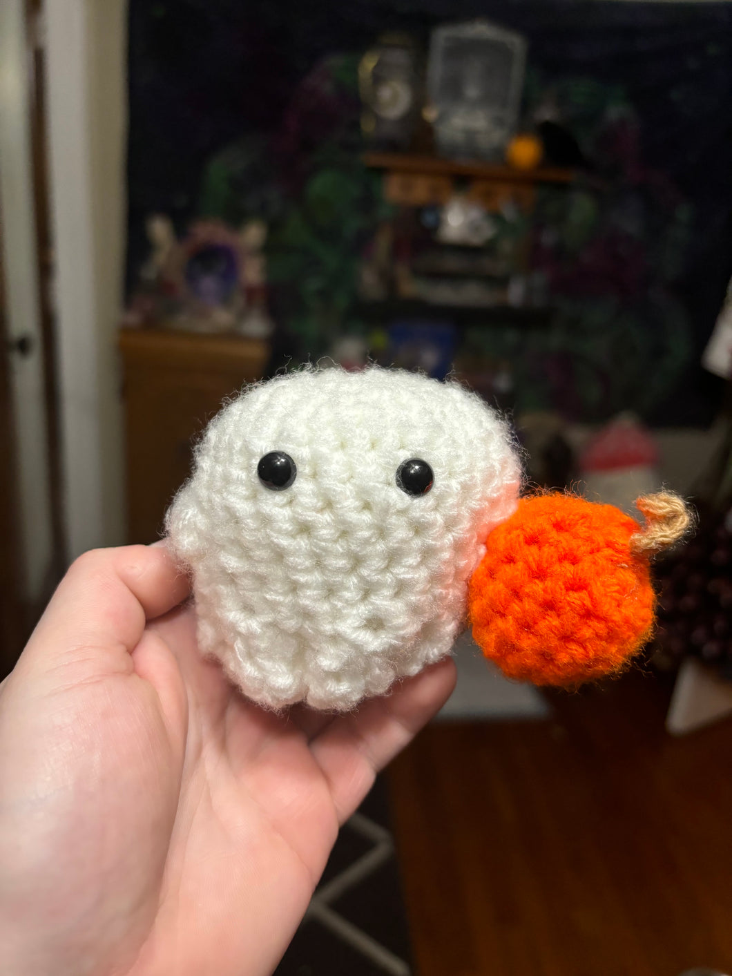 Little Crochet Ghost holding a pumpkin